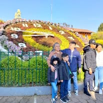 Familia en frente de un reloj floral gigante